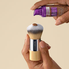 CoverGirl blending brush with a hand dispensing product from a bottle