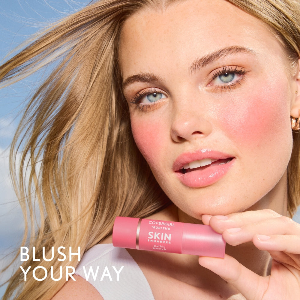 Model holding CoverGirl TruBlend Skin Enhancer Blush Balm with a natural blush look.
