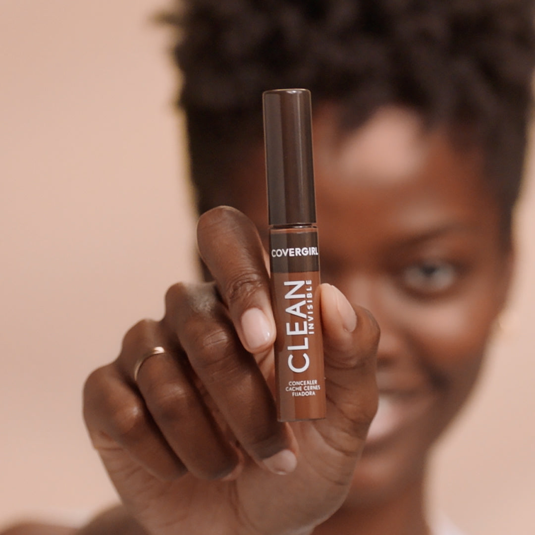 Model holding CoverGirl Clean Invisible Concealer in 101 Porcelain.