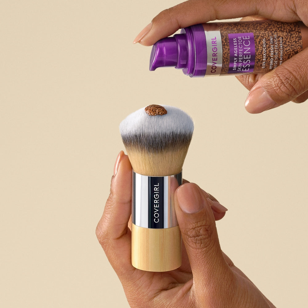 CoverGirl blending brush with a hand dispensing product from a bottle
