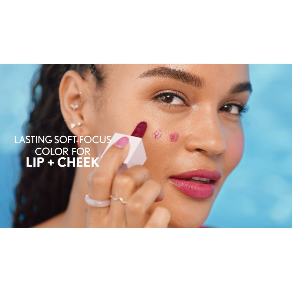 Model applying Clean Fresh Jelly Water Tint in Raspberry Drops on lips and cheeks.
